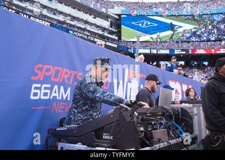 East Rutherford, N.J. (6 novembre 2016) ingegnere Audio Petty Officer 1. Classe Chris Trupe mescola la produzione di un Halftime spettacolo da parte del governo degli STATI UNITI La banda della marina militare a livello nazionale partita di calcio tra New York Giants e Philadelphia Eagles. I membri dell'U.S. La banda della marina Sea Chanters chorus incrociatori e ensemble di musica contemporanea eseguita sul campo a MetLife Staduim durante un tempo di emisaturazione mostrano il supporto di NFL's 'Salute per servizio' gioco tra New York Giants e Philadelphia Eagles. Foto Stock