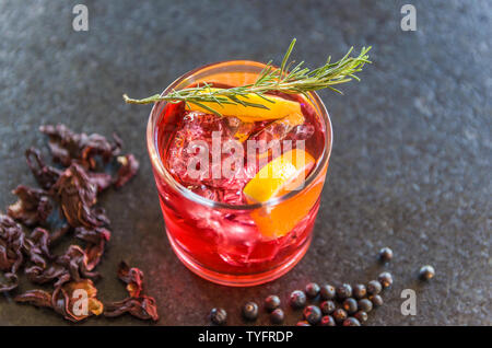 Bella hibiscus kombucha cocktail con il gin e la vodka, decorata con ramo di rosmarino. Foto Stock