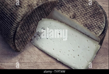 Formaggio artigianale da mucche e capre latte. Testa di formaggio. Messa a fuoco selettiva Foto Stock