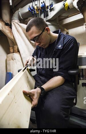 Golfo (nov. 7, 2016) Petty Officer di terza classe Michael Lloyd scalpelli eccesso di legno da una scheda nel negozio di falegnameria a bordo della portaerei USS Dwight D. Eisenhower CVN (69) (IKE). Lloyd serve a bordo di IKE come uno scafo tecnico di cui è attualmente assegnato al negozio di falegnameria. Ike e la sua portante Strike gruppo vengono distribuiti a supporto di funzionamento inerenti risolvere, le operazioni di sicurezza marittima e di teatro la cooperazione in materia di sicurezza gli sforzi negli Stati Uniti Quinta Flotta area di operazioni. Foto Stock