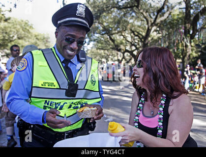 New Orleans funzionario di polizia M.D. White accetta un hot dog da spettatore di Carnevale Donna LeBlanc su St. Charles Avenue in uptown New Orleans durante il primo fine settimana del Mardi Gras parate, 8 febbraio 2015. Soleggiato e caldo ha portato migliaia di persone a picnic, perle di cattura e guardare le sfilate. Foto di A.J. Sisco/UPI Foto Stock