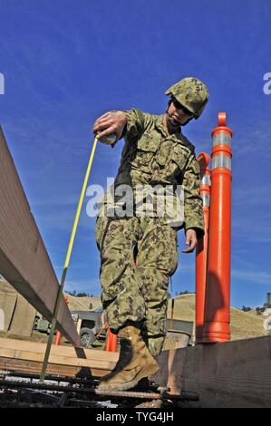 HUNTER LIGGETT, ca. (Nov. 7, 2016) - Petty Officer 2a classe Kelsey pozzetti con Naval Mobile Battaglione di costruzione 18 (NMCB 18) misure sotto forma di profondità per un decollo ed atterraggio verticali pad progetto di costruzione durante una formazione sul campo di allenamento (FTX). NMCB 18 sta partecipando a questa FTX per mantenere la fattibilità dell'installazione. Foto Stock