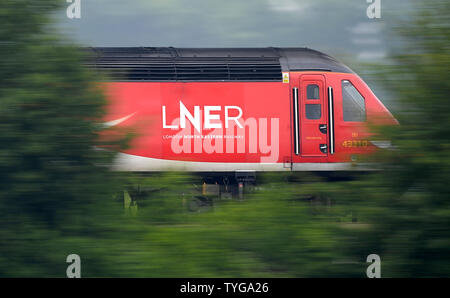 Un London North Eastern Railway (LNER) treno passa attraverso sabbioso nel Cambridgeshire. Foto Stock