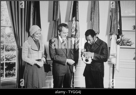 Il presidente Nixon incontro con Edson Pelé Arantes do Nacimento, pensionato brasiliano professionali giocatore di calcio e direttore del calcio internazionale programma sponsorizzato da PepsiCo. Pele autografi di un pallone da calcio per il presidente Nixon, campo di applicazione e il contenuto: nell'immagine: Sig.ra Edson Arantes do Nacimento, Presidente Richard M. Nixon, Edson Pelé Arantes do Nacimento, pensionato brasiliano giocatore di calcio. Oggetto: Sport. Foto Stock