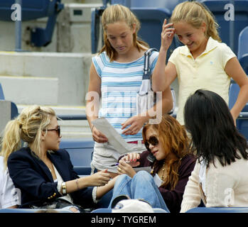 Olson twins Ashley, seduto ,a sinistra e Mary-Kate, seduto a destra, firmare autografi come essi frequentano uomini della semi-finale corrisponde a US Open svoltasi presso il National Tennis Center Settembre 11, 2004 a Flushing Meadows a New York City. (UPI foto/Monika Graff) Foto Stock