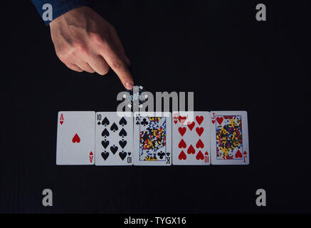 Primo piano della mano di guy, giocatore di poker bluff, come le scommesse un chip. Giocare al casino tavolo da gioco, sconosciuto di combinazione di carte. Torneo di gioco d'azzardo, p Foto Stock