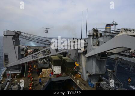 Golfo di Aden (nov. 9, 2016) Un come-332 Super Puma elicottero offre un pallet di forniture per il ponte di volo del dock anfibio sbarco nave USS Whidbey Island (LSD 41) come marinai e Marines formano un gruppo di lavoro sulla coperta della imbarcazione per riporre i materiali di consumo. Whidbey Island viene distribuito con la Vespa Anfibia gruppo pronto per supportare le operazioni di sicurezza marittima e di teatro la cooperazione in materia di sicurezza gli sforzi negli Stati Uniti Quinta Flotta area di operazioni. Foto Stock