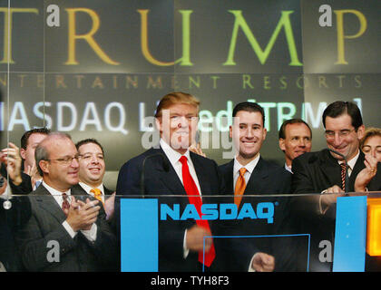 Donald Trump, centro, presidente della Trump Entertainment Resorts, reagisce dopo aver squillato il opeing campana al NASDAQ exchange come egli è entrato a far parte da Scott Butera, terza a destra,vice presidente esecutivo e Bob Greifeld, destra, presidente del Nasdaq per la campana opeing cereomony il 20 settembre 2005 a New York City. Trump Entertainment Resorts, che opera numerosi casinò e hotel, è notando il suo primo giorno di negoziazione su scambio elettronico.(UPI foto/Monika Graff) Foto Stock