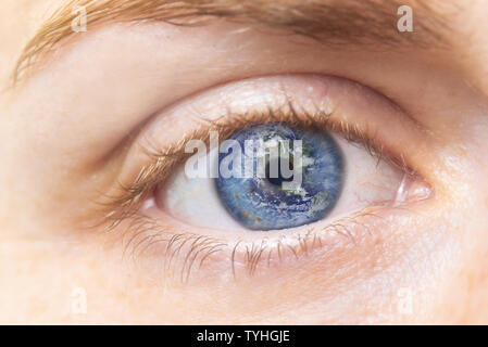La conservazione dell ambiente concetto. Chiudere l immagine della donna occhio con messa a terra. Creative composito di macro occhio con la terra come Iris. Gli elementi di questa immagine fornita da NASA . Foto Stock