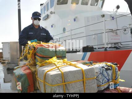 Coast Guard trasferita la custodia dei due sospetti di contrabbandieri e più balle di cocaina alla legge federale alle autorità incaricate di far rispettare la legge a Coast Guard Settore San Juan a San Juan, Puerto Rico nov. 10, 2016. In totale, 1.158 libbre di cocaina con una stima di valore all'ingrosso di $13.1 milioni di euro sono stati sequestrati come risultato multi-agenzia legge gli sforzi a sostegno dell'operazione Unified risolvere e funzionamento dei Caraibi di protezione. Foto Stock