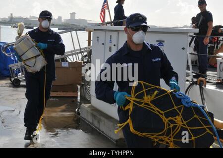 Coast Guard trasferita la custodia dei due sospetti di contrabbandieri e più balle di cocaina alla legge federale alle autorità incaricate di far rispettare la legge a Coast Guard Settore San Juan a San Juan, Puerto Rico nov. 10, 2016. In totale, 1.158 libbre di cocaina con una stima di valore all'ingrosso di $13.1 milioni di euro sono stati sequestrati come risultato multi-agenzia legge gli sforzi a sostegno dell'operazione Unified risolvere e funzionamento dei Caraibi di protezione. Foto Stock