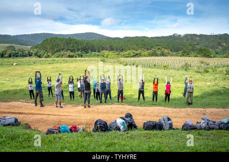 Un gruppo di turisti sono in fase di riscaldamento per avviare il trekking lungo il Ta Nang-Phan sterco di percorso attraverso le colline di erba e foreste nel brano Mao natura nazionale Foto Stock