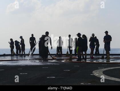 Golfo di Aden (nov. 11, 2016) marinai lavi giù il ponte di volo del dock anfibio sbarco nave USS Whidbey Island (LSD 41) con acqua fresca. Whidbey Island viene distribuito con la Vespa Anfibia gruppo pronto per supportare le operazioni di sicurezza marittima e di teatro la cooperazione in materia di sicurezza gli sforzi negli Stati Uniti Quinta Flotta area di operazioni. Foto Stock