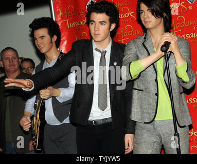 Il Jonas Brothers: Kevin Jonas sembra essere parlando di cera figura Joe Jonas (l a r)mentre posa con la loro somiglianza al scoprimento delle loro figure di cera di Madame Tussauds a New York il 12 febbraio 2009. (UPI foto/Ezio Petersen) Foto Stock