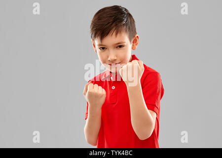 Ragazzo in t-shirt rossa mostra i pugni o il pugilato Foto Stock