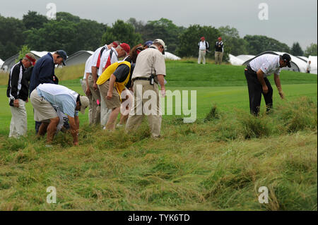 Angel Cabrera (R) e funzionari USGA cercare Cabrera della palla in grezzo a fianco del xviii fairway durante il primo round di U.S. Aperto a Bethpage Black in Farmingdale, New York il 19 giugno 2009. Primo Round è stata ripresa questa mattina dopo forti piogge hanno costretto i funzionari USGA per sospendere la riproduzione di ieri. (UPI foto/Kevin Dietsch) Foto Stock