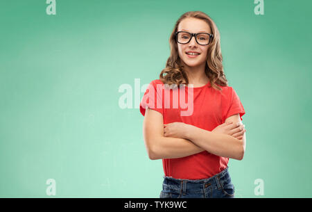 Studente sorridente ragazza in bicchieri sulla scheda verde Foto Stock