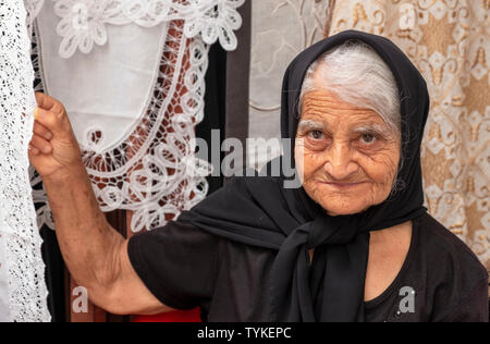 Una signora pizzi di vendita in un mercato in stallo in Paphos città vecchia, Cipro. Foto Stock