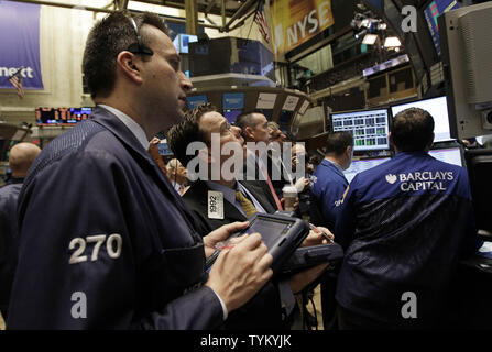 Wall Street employes sono impegnati a momenti di lavoro prima della campana di apertura sul pavimento del NYSE su Wall Street a New York City il 25 agosto 2010. UPI/John Angelillo Foto Stock