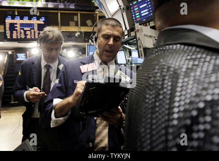 Wall Street employes sono impegnati a momenti di lavoro prima della campana di apertura sul pavimento del NYSE su Wall Street a New York City il 25 agosto 2010. UPI/John Angelillo Foto Stock