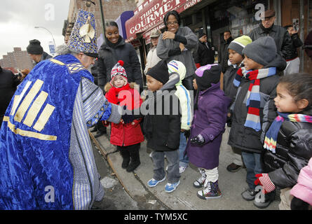 Papaluto Melendez è vestito come un re come egli saluta la scuola dei bambini che guardano i tre re sfilata in Harlem su Gennaio 6, 2011 a New York City. Tre Re giorno, chiamato anche epifania,celebra il re itinerario biblico per vedere il bambino Gesù a Betlemme e offrono doni. UPI /Monika Graff Foto Stock