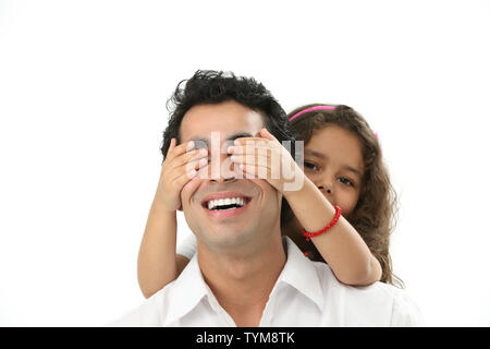 Ritratto di una ragazza che coprono il suo padre gli occhi da dietro Foto Stock