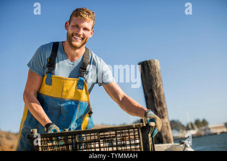 Giovane uomo di scarico pentole di molluschi. Foto Stock