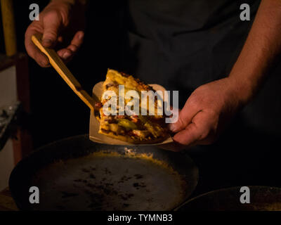 Man picking up pizza slice Foto Stock