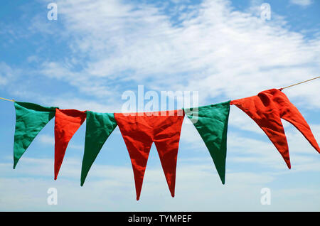 Blu e rosso fiamme appeso sopra il cielo blu Foto Stock