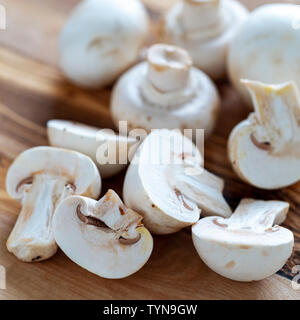 Bicchiere chiuso funghi prataioli vicino sul tagliere di legno Foto Stock