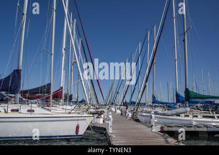 Barca a vela Dock: righe della vela sloops affacciati uno all'altro attraverso un molo in legno sul Lago Superiore nel Wisconsin settentrionale. Foto Stock