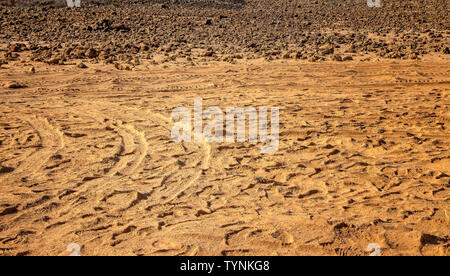 Tracce di pneumatici nella sabbia del deserto. Le tracce delle ruote sul terreno. È lo sfondo con un buggy tracce. Foto Stock