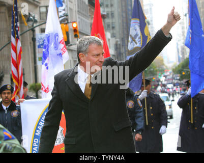 Sindaco-elect Bill deBlasio onde alle folle come lui marche fino alla Fifth Avenue durante il 92Veterani annuale parata del giorno su Novembre 11, 2013 a New York City. Si stima che 20.000 reduci di tutte le epoche di marzo nella nazione di veterani più grande parata del giorno come essi vengono premiati per il loro negli Stati Uniti il servizio militare. UPI /Monika Graff. Foto Stock