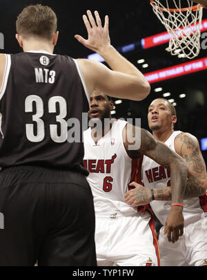 Miami Heat LeBron James cariche al Brooklyn Nets Mirza Teletovic dopo Teletovic viene chiamato per una flagrante fallo su James nel quarto trimestre presso Barclays Center a New York City il 10 gennaio 2014. Le reti sconfitto il calore 104-95 in doppia le ore di lavoro straordinario. UPI/John Angelillo Foto Stock