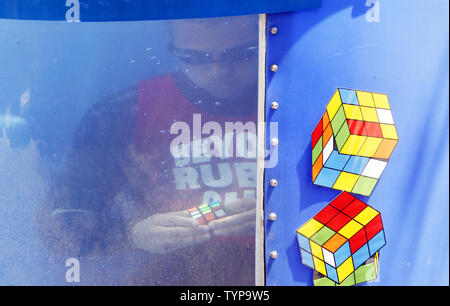North American velocità campione del cubo di Anthony Brooks risolve un cubo di Rubik puzzle in un serbatoio di acqua come egli tenta di rompere i record Guinness per la maggior parte risolti cubetti sott'acqua in un respiro a livello nazionale il cubo di Rubik campionato al Liberty Science Center di Jersey City, NJ il 1 agosto 2014. Brooks impostare un nuovo record di risoluzione di 5 cubi in 1:18 battendo il vecchio record di registrazione di 4 cubi risolto in 1:30. UPI/John Angelillo Foto Stock