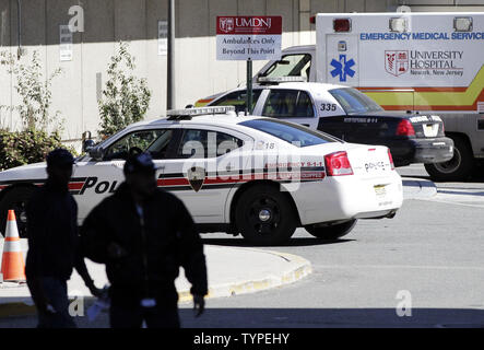 Una macchina della polizia aziona attraverso il parcheggio della University Hospital di Newark NJ il 27 ottobre 2014. Kaci Hickox, un infermiere trattare pazienti di Ebola in Africa occidentale, si è svolta in una tenda all'interno di un ala del New Jersey Medical Center dal momento che lei è stato tolto un volo e forzatamente in quarantena in New Jersey dopo che lei è venuto a casa. Hickox è stato rilasciato oggi e viene trasportato alla salute funzionari nel Maine che hanno informato del suo regime e sarà in grado di effettuare una determinazione sotto le proprie leggi sul suo trattamento quando arriva. UPI/John Angelillo Foto Stock