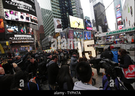 Media e gli spettatori si riuniscono intorno al 2015 Capodanno numerici dopo che essi sono illuminati in Times Square a New York City il 16 dicembre 2014. Il gigante, sette piedi di altezza '15' è arrivato su un autocarro a pianale sulla 46th Street e Broadway Martedì, 16 Dicembre alle ore 11.00. I numeri sarà portata alla sommità di una Times Square dove potranno riposare per un paio di giorni prima di completare il "2-0-1-5" segno che illumina a mezzanotte di Capodanno per annunciare l inizio del nuovo anno al completamento della sfera Drop. UPI/John Angelillo Foto Stock