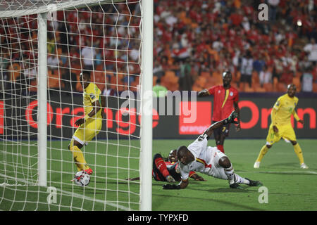 Il Cairo, Egitto. Il 26 giugno, 2019. Uganda portiere Denis Mwanake (C) consente di risparmiare durante il 2019 Africa Coppa delle Nazioni di una partita di calcio tra Uganda e Zimbabwe a Il Cairo International Stadium. Credito: Omar Zoheiry/dpa/Alamy Live News Foto Stock