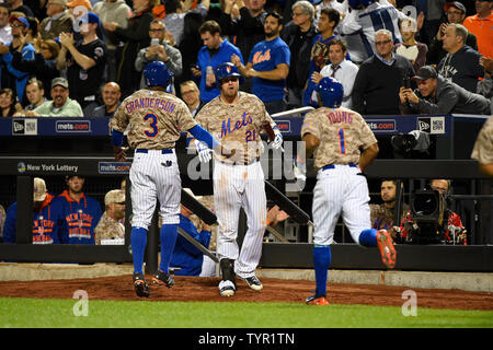New York Mets diritto fielder Curtis Granderson (3) e center fielder Eric Young Jr. (1) sono accolti presso la piroga da Mets primo baseman Lucas Duda (21) dopo il punteggio su un 2 eseguire rbi doppio da Mets terzo baseman Daniel Murphy (non raffigurata) nel 7 inning contro Atlanta Braves presso Citi Field di New York il 21 settembre 2015. Foto di ricca Kane/UPI Foto Stock
