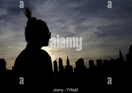 Un sostenitore attende per il candidato democratico alla presidenza Bernie Sanders a parlare con la skyline di Manhattan dietro di lui in un rally in Sud cacciatori Park il 18 aprile 2016 a New York City. Il discorso arriva alla vigilia del New York principale su Aprile 19th. Foto di Giovanni Angelillo/UPI Foto Stock