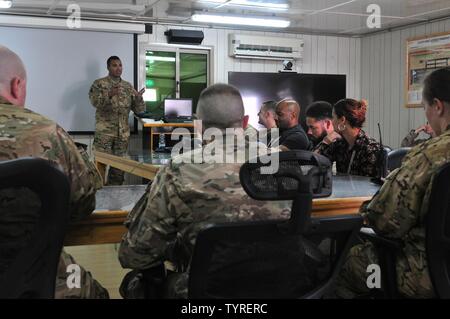 Capo garantisce 2 David Zahn, airfield operations officer sicurezza con il 1° Airfield Operations battaglione, 245Reggimento di aviazione, conduce una dopo l azione di revisione dopo un strumento inadvertant condizioni meteorologiche esercitazione a Camp Buehring, Kuwait nov. 22, 2016. Zahn coordinato la manifestazione per testare le capacità e i tempi di risposta a reagire a aerei di atterraggio in emergenza e in condizioni atmosferiche avverse. Foto Stock