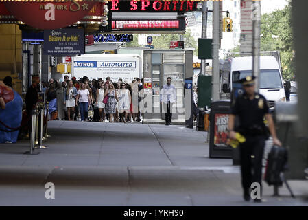 Pedoni guarda come NYPD un funzionario di polizia porta via un sacco di Times Square dopo le relazioni di un pacchetto sospetto inviato forze di polizia e la Bomb Squad di scena il 21 settembre 2016 a New York City. Il pacchetto si è rivelata essere una valigia vuota e del tutto chiaro è stato dato poco dopo. Le tensioni sono ancora alta giorni dopo l'esplosione di una bomba è andato fuori sulla West 23rd Street a Manhattan su Sabato, ferendo 29 persone, fracassando windows e richiede una diffusa street chiusure su West 23rd Street. Foto di Giovanni Angelillo/UPI Foto Stock