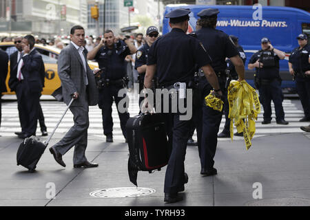 Un NYPD funzionario di polizia porta via un sacco di Times Square dopo le relazioni di un pacchetto sospetto inviato forze di polizia e la Bomb Squad di scena il 21 settembre 2016 a New York City. Il pacchetto si è rivelata essere una valigia vuota e del tutto chiaro è stato dato poco dopo. Le tensioni sono ancora alta giorni dopo l'esplosione di una bomba è andato fuori sulla West 23rd Street a Manhattan su Sabato, ferendo 29 persone, fracassando windows e richiede una diffusa street chiusure su West 23rd Street. Foto di Giovanni Angelillo/UPI Foto Stock