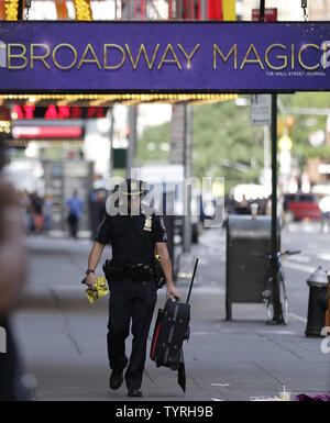 Un NYPD funzionario di polizia porta via un sacco di Times Square dopo le relazioni di un pacchetto sospetto inviato forze di polizia e la Bomb Squad di scena il 21 settembre 2016 a New York City. Il pacchetto si è rivelata essere una valigia vuota e del tutto chiaro è stato dato poco dopo. Le tensioni sono ancora alta giorni dopo l'esplosione di una bomba è andato fuori sulla West 23rd Street a Manhattan su Sabato, ferendo 29 persone, fracassando windows e richiede una diffusa street chiusure su West 23rd Street. Foto di Giovanni Angelillo/UPI Foto Stock