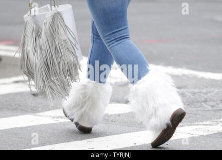 Una donna che indossa scarponi invernali attraversa una strada a Manhattan in una giornata di vento con temperature nei metà di anni 40 il 28 ottobre 2016 nella città di New York. Foto di Giovanni Angelillo/UPI Foto Stock