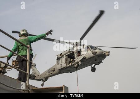 Golfo (nov. 23, 2016) Petty Officer 2a classe Giulietta Scarlott dirige un MH-60S Sea Hawk elicottero assegnato per il polveroso cani di elicottero di mare squadrone di combattimento (HSC) 7 durante un rifornimento verticale a bordo del combattimento veloce nave appoggio USNS Arctic (T-AOE 8). Artico è implementato il supporto di coalizione forze marittime navi negli Stati Uniti Quinta Flotta area di operazioni. Foto Stock