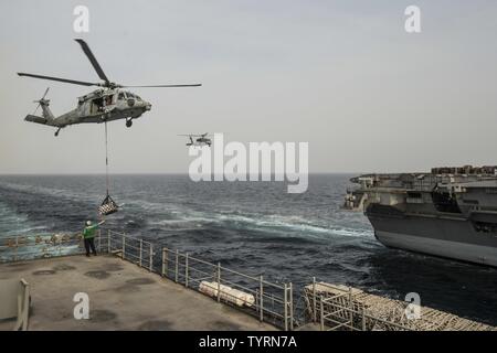 Golfo (nov. 23, 2016) Petty Officer 2a classe Giulietta Scarlott dirige un MH-60S Sea Hawk elicottero assegnato per il polveroso cani di elicottero di mare squadrone di combattimento (HSC) 7 durante un rifornimento verticale a bordo del combattimento veloce nave appoggio USNS Arctic (T-AOE 8). Artico è implementato il supporto di coalizione forze marittime navi negli Stati Uniti Quinta Flotta area di operazioni. Foto Stock