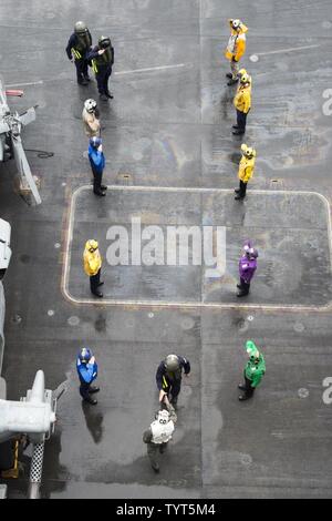 Golfo (nov. 25, 2016) Comandante Capt. Paul C. Spedero Jr. saluta Cdre. Andrew Burns, prospective commander, il comando Task Force (CTF) 50, sul ponte di volo della portaerei USS Dwight D. Eisenhower CVN (69) (IKE). Ike e la sua portante strike gruppo vengono distribuiti a supporto di funzionamento inerenti risolvere, le operazioni di sicurezza marittima e di teatro la cooperazione in materia di sicurezza gli sforzi negli Stati Uniti Quinta Flotta area di operazioni. Foto Stock