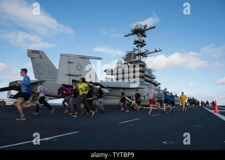 Oceano Pacifico (nov. 27, 2016) marinai eseguire un 5k " Turchia trotto' sponsorizzata dalla morale, benessere e svaghi sul USS John C. Stennis' (CVN 74) ponte di volo. John C. Stennis è in corso per condurre la formazione di routine e partecipare nella legislazione nazionale in materia di Pearl Harbor giorno del ricordo di eventi nelle Hawaii. Foto Stock