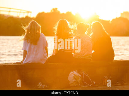 Hannover, Germania. Il 26 giugno, 2019. Quattro giovani donne siedono presso il Maschsee durante il tramonto. Credito: Christophe Gateau/dpa/Alamy Live News Foto Stock